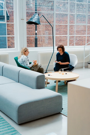 Two colleagues talking in a modern office lounge