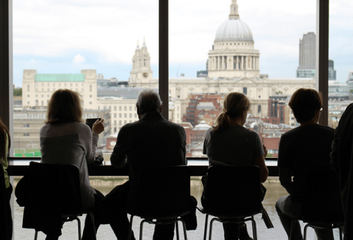 Audience seated at a conference overlooking a city skyline
